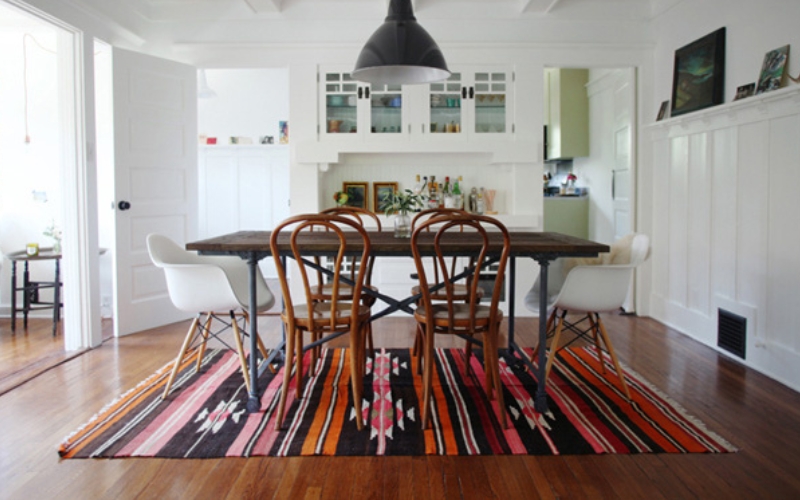 a rug under a dining table and chairs in a room