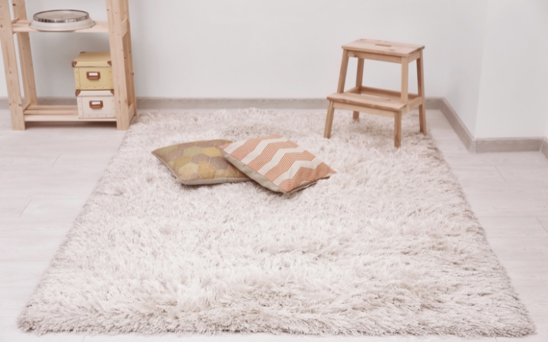 a white shaggy rug with pillows on it