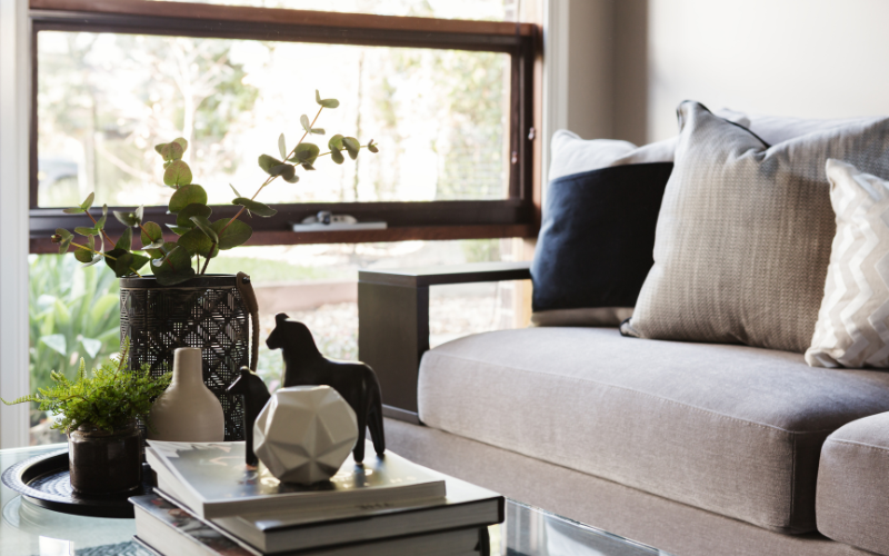 a couch with a vase and a table with a plant in front of it