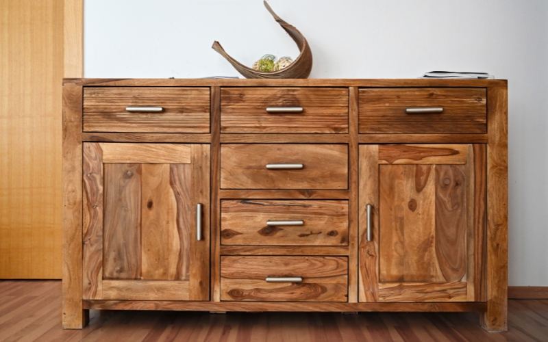 a wooden cabinet with drawers and a bowl on top