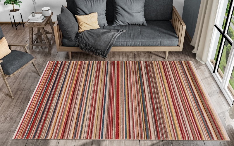 a colorful striped rug next to a couch