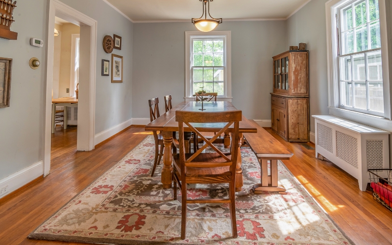 a dining room with a table and chairs on a vintage rug