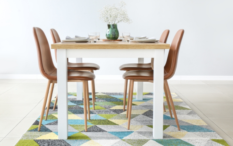 a wooden dining table with chairs and a vase on it