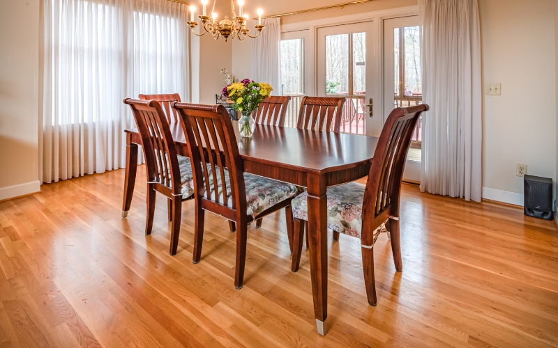 a wooden dining table with chairs in a room with a chandelier